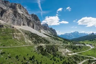 Grey limestone walls above the Valparola road, with the pass road cutting across scree slopes below